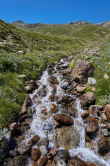 Wasserlauf mit kleinen Wasserfällen in den Bergen Alpen