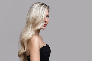 Blond woman on gray background. Hair care and coloring concept. Copycpase Wavy Hairstyle