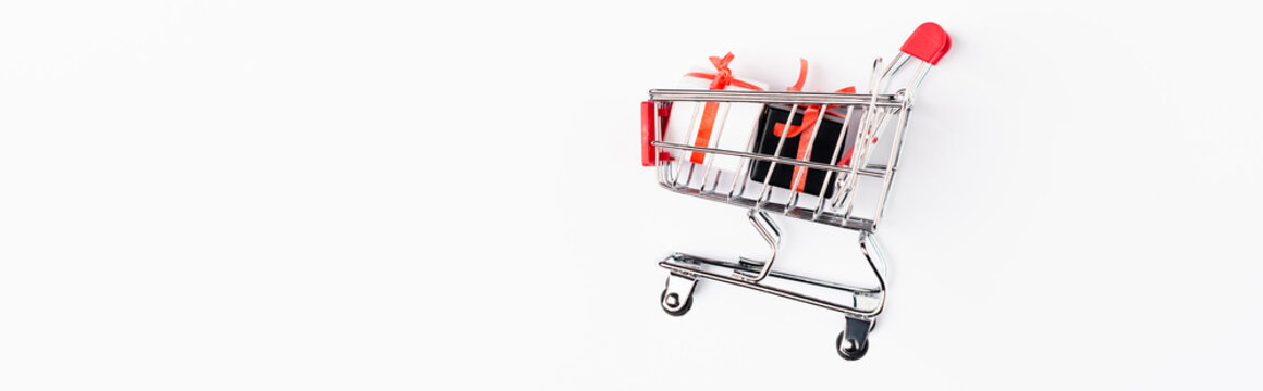 Horizontal image of toy gift boxes and shopping cart on white background