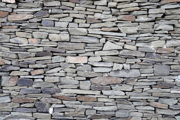 Stone wall surface texture from natural gray stone without cement pouring, background