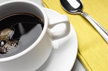 Closeup of refreshing coffee cup with napkin and spoon