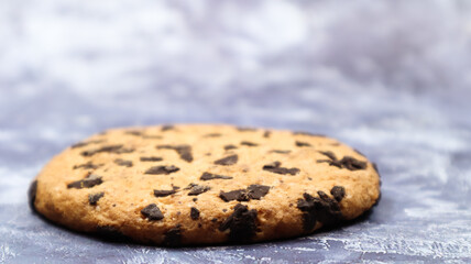One soft, freshly baked chocolate chip cookie on a gray marble kitchen countertop. American traditional dessert. Delicious sweet food. Homemade baking concept for the holiday. Culinary background