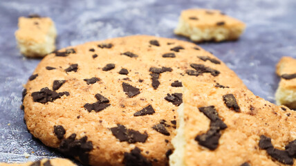 One soft, freshly baked chocolate chip cookie on a gray marble kitchen countertop. American traditional dessert. Delicious sweet food. Homemade baking concept for the holiday. Culinary background