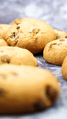 Soft, freshly baked chocolate chip cookies on a gray marble kitchen countertop. American traditional sweet pastry pastry, delicious homemade dessert. Culinary background. Selective focus