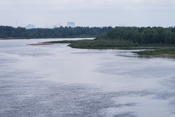 River Pripyat in Chernobyl exclusion zone with nuclear power plant on horizon