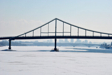 Winter cityscape. Pedestrian bridge across the Dnieper river. Kiev (Kyiv), Ukraine.