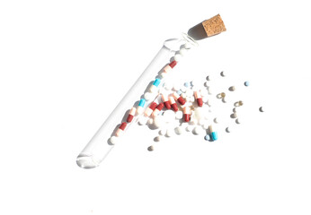 Piles with capsule and test tube. Pill bottle spilling pills on to surface isolated on a white background. Homeopathy.