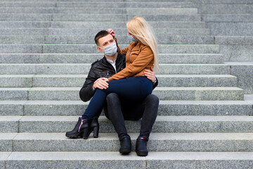 Young couple in protective medical mask on face outdoor at street. Guy and girl in virus protection.