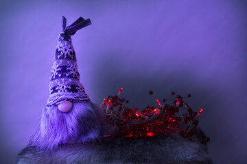 Elfo de madera con gorro de lana y luces de navidad - obrazy, fototapety, plakaty