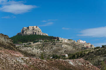 Fototapeta na wymiar Landscape of the village of Morella with the walled city and the castle on the top of the hill on a day with blue sky and clouds, Morella, Castellon, Spain