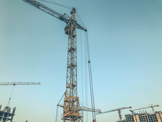 construction pit. construction site of the new district. metal lifting cranes. construction of concrete tall buildings in gray. large concrete boxes. urban landscape