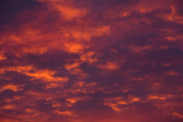 Stormy clouds and crimson sunset. Purple glow on the evening clouds. Sky patterns as background.