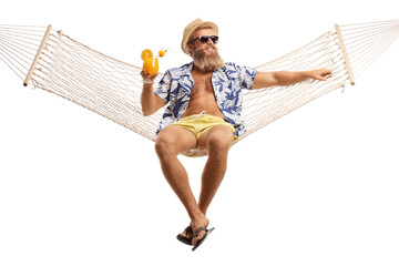 Young bearded guy sitting on a hammock net with a cocktail