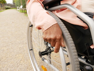 Close-up of the hand of a black woman pushing her wheelchair