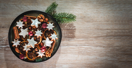 Teller mit selbstgebackenen Keksen und Zimtsterne auf hölzernen Untergrund zur Weihnachtszeit