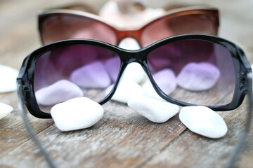 Fototapeta na wymiar beautiful background black sunglasses and seashells, vacation background