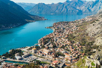 Fototapeta na wymiar Beautiful panoramic view of Dobrota Bay in Kotor and Old Town in a sunny day. Kotor is very popular city for tourists and has a pier for cruise ships.
