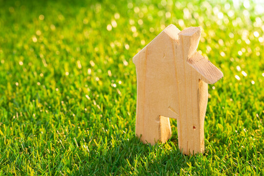 Wooden toy house miniature on grass close up