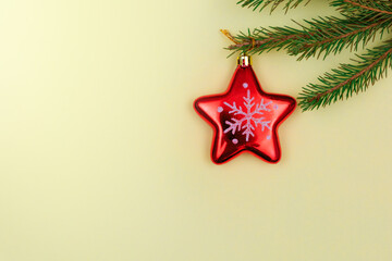 Christmas texture on a yellow background Christmas toy red star surrounded by spruce branches.