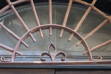 decoration with a fleur-de-lis- made of cast iron above a door