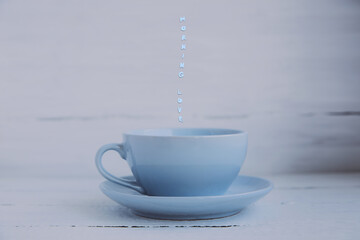 The blue cup and saucer on a light wooden background and the inscription morning love.