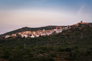 Fototapeta na wymiar Landscape of the historic town of Villafames surrounded by trees at sunset with the castle on the top of the hill, Castellon, Spain