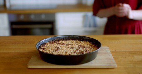 A photo of a crumble pie in an oven dish in a kitchen