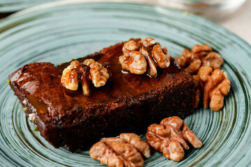 Piece of chocolate cake with nuts on green plate