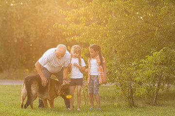 Obraz premium Grandfather And Granddaughters Taking Dog For Walk