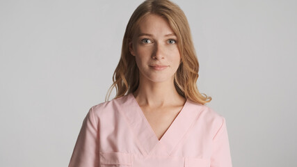 Fototapeta premium Beautiful nurse in uniform confidently looking in camera isolate