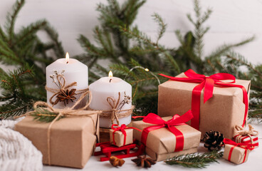 Fototapeta na wymiar Christmas burning candles and garland, fir branches, gifts and ribbon