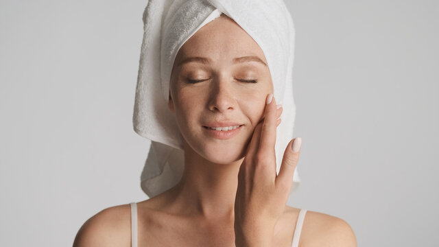 Beautiful girl with smooth skin and towel on head sensually posi