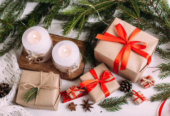 Christmas burning candles and garland, fir branches, gifts and ribbon