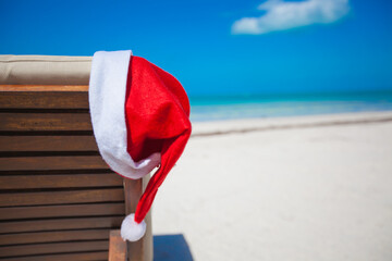 Close-up of santa hat on chair longue at tropical caribbean beach
