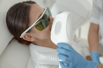 Naklejka premium Beautiful healthy smiling caucasian woman is doing beauty procedures at spa and healthcare salon