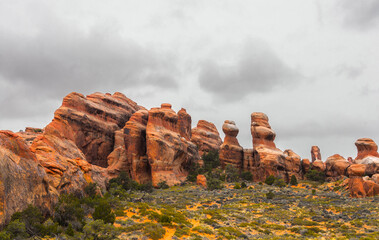 Rounded red rocks under a cloudy sky.