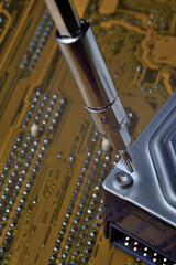 disassembling a computer hard drive using a screwdriver to diagnose and repair problems.