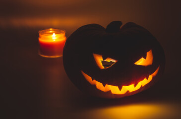 a lantern of a pumpkin prepared for Halloween on a dark background with a candle burning inside