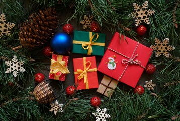 Colorful Christmas gifts and toys on the background Christmas tree branches. Christmastime 