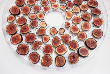 Fig. Purple berries with red flesh are cut into round slices. Laid out on a grid dehydrator. The preparation of wholesome snacks. Dried fruits.