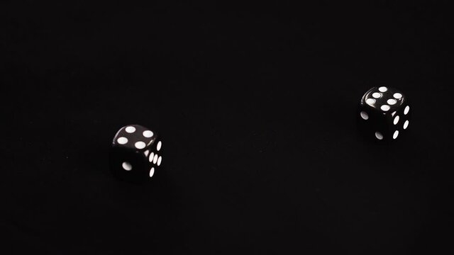 Close up throwing double dice on black background in casino. Gambler rolling cubes dice four and six on game table. Gambling, casino play concept - Powered by Adobe