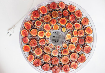 Fig. Purple berries with red flesh are cut into round slices. Laid out on a grid dehydrator. The preparation of wholesome snacks. Dried fruits.