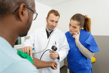 nurse and doctor measuring patient heart pressure