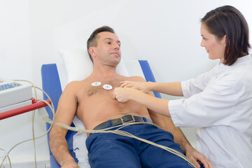 Nurse attaching heart monitor pads to patient