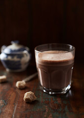 Glass of chocolate milkshake on dark wooden background. Close up.