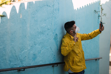 Chico con abrigo amarillo en calles azules de Júzcar en Andalucía