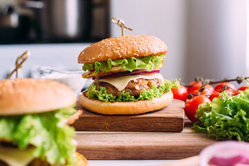 Two home made fresh tasty burgers with lettuce and cheese.