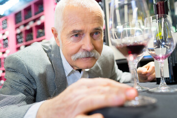 old man comparing the wine