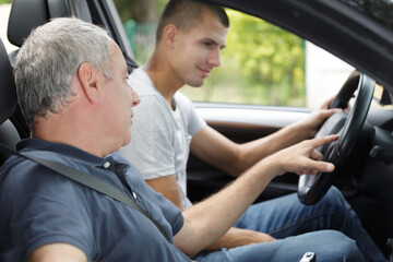 Fototapeta young man having a accompanied driving lesson obraz
