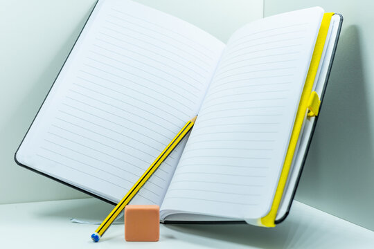 A nice notebook or diary together with a pen and an eraser, isolated with a white background